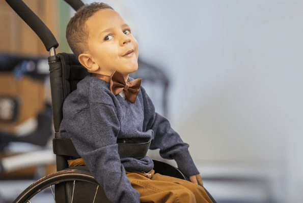 A young boy in a wheelchair looking off into the distance
